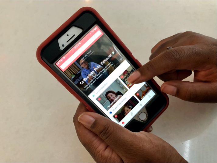 A close-up of two hands holding a phone with the Quillo app open.