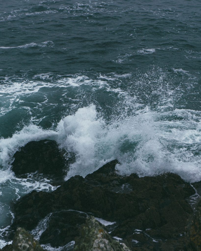 Image of turbulent waves crashing into rocks.